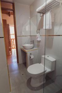 a white bathroom with a toilet and a sink at Casa Alba Ollantaytambo in Ollantaytambo +42 photos