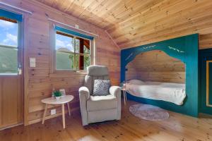 una camera da letto in una baita di tronchi con un letto e una sedia di Fjord Lodge direkt am Ufer des Dalsfjord a Lauvstad