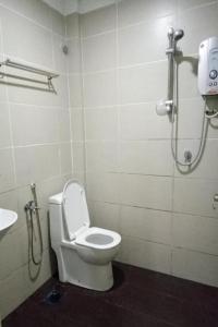 a bathroom with a white toilet and a sink at Hotel Mutiara KGMMB in Melaka