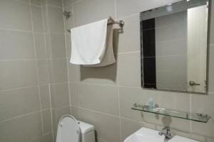 a bathroom with a toilet and a mirror and a sink at Hotel Mutiara KGMMB in Melaka