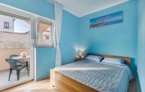 a blue bedroom with a bed and a window at Apartments Armin in Ližnjan