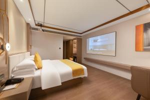 潮州Poltton International Hotel - Chaozhou Hanjiang的配有床和书桌的酒店房间