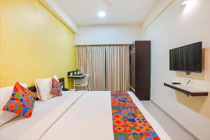 Una habitación de hotel con una cama y un televisor. en FabHotel Sky View Palace - Marathahalli Outer Ring Road, en Bangalore