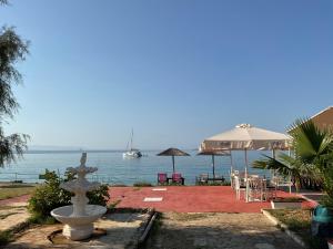 a fountain with a view of the water and a boat at Kefalonia Beach Hotel & Bungalows in Lixouri