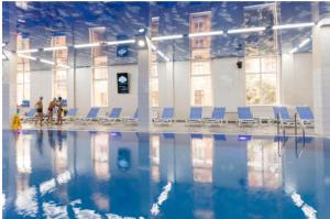 a swimming pool with blue chairs in a building at Astashkina in Odesa