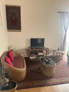 un soggiorno con un divano e un tavolo di Moonwind, two bedroom apartment with sitting room and Kitchenette a Mussoorie