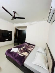 纳特杜瓦拉Hotel Chandram - 450mtr I 10min walking from ShreeNath Ji temple Nathdwara 966o9o1oo6的带床和吊扇的卧室