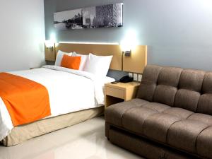 a hotel room with a bed and a couch at Hotel Urbainn in Veracruz