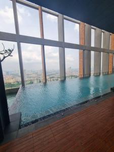 a swimming pool in a building with large windows at Luxury 2bedroom suite near Midvalley - Millerz Square in Kuala Lumpur