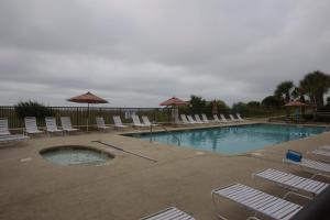 una piscina con sillas y sombrillas en Peppertree by the Sea by Capital Vacations, en Myrtle Beach