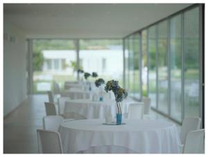 a row of tables with white chairs and flowers on them at Hotel Villa San Bartolo in Vittoria +77 photos