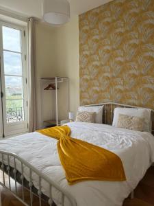 a bedroom with a bed with a yellow blanket on it at Quai de la Loire in Blois