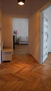 a living room with a wooden floor and an open door at Center Apartment in Warsaw