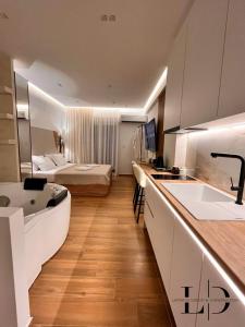 a kitchen with a sink and a room with a bed at City break 1 LeD & Bath in Volos