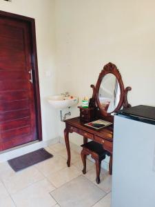 a bathroom with a sink and a mirror on a table at Bangbang Guest House Ubud in Ubud