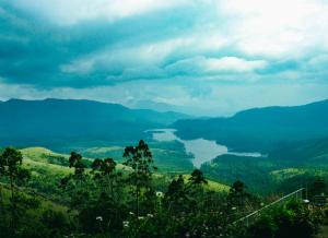 a view of a lake in the middle of a valley at Campper Campwoody Munnar in Munnar