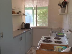 a kitchen with a stove and a sink and a window at Sun on the Stubble in Maitland