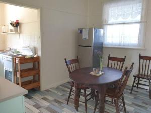 a kitchen with a wooden table and a refrigerator at Sun on the Stubble in Maitland +7 photos