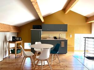 a kitchen with a table and chairs in a room at Soleil et Ressourcement in Ucel