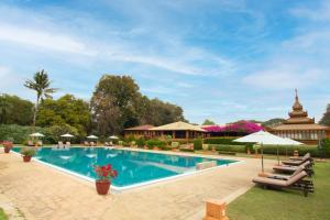 una piscina in un resort con sedie e ombrelloni di Bagan Thiripyitsaya Sanctuary Resort a Bagan