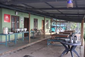 a group of tables and benches in front of a building at Campper Campwoody Munnar in Munnar