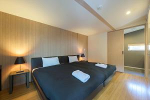 a bedroom with a large bed with two white pillows at Forest Estate in Niseko