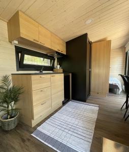 a kitchen with wooden cabinets and a rug in a room at Beach house with sauna in Hanko