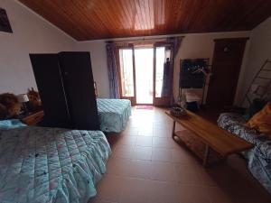 a bedroom with two beds and a wooden table at Tranquil and Spacious Townhouse in Historical and Picturesque Cervera Del Maestre in Cervera del Maestre