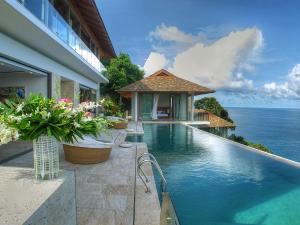 a swimming pool with a view of the ocean at Villa Minh in Kamala Beach