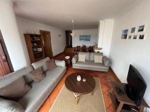 uma sala de estar com um sofá e uma mesa em Casa S & S em São Martinho do Porto