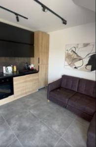 a living room with a couch and a kitchen at Apartman sa pogledom na Ozren in Soko Banja
