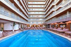 a swimming pool in a hotel with a large building at tent Bahia de Palma in El Arenal