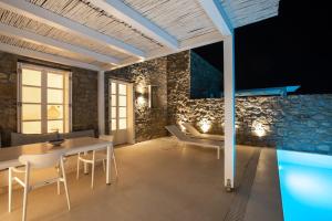 a room with a table and chairs and a swimming pool at The Ammonite Resort in Super Paradise Beach