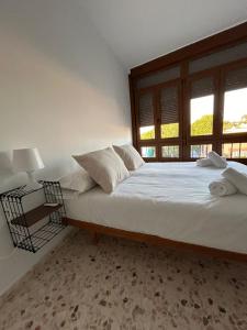 ein Schlafzimmer mit einem großen weißen Bett mit einem Fenster in der Unterkunft Casa Mariquilla in Sanlúcar de Barrameda