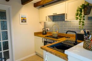 eine Küche mit Spüle und Theke in der Unterkunft The Hangmans Cottage in Abbotskerswell + 16 Fotos