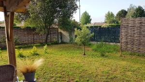 a backyard with a fence and a small tree at maison proche du lac in Aureilhan