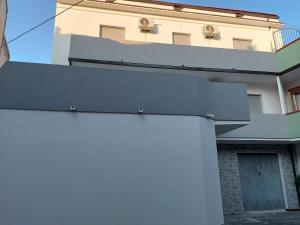 a white house with a gray roof and a building at A casa di Adua in Cupello
