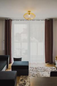 a living room with a couch and a large window at Dom Goscinny Bialy Dworek in Człuch&oacute;w