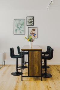 a table with chairs and a vase with flowers on it at Dom Goscinny Bialy Dworek in Człuch&oacute;w