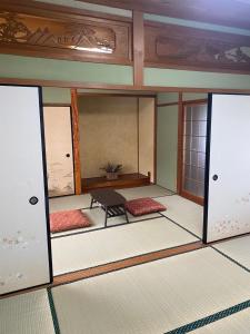 una stanza con porte e un tavolo al suo interno di Guesthouse85BASE a Suo Oshima