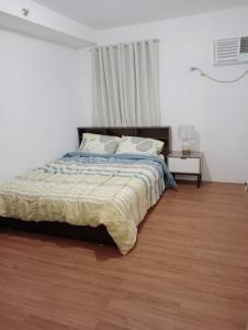a bedroom with a bed and a wooden floor at Condotel in Pasig City - Hampton Gardens in Manila