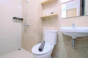 a bathroom with a toilet and a sink and a shower at Minimalist and Good Deal Studio Transpark Cibubur Apartment By Travelio in Depok