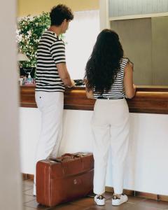 a man and a woman looking out of a window at Hotel du Port in Canet-en-Roussillon