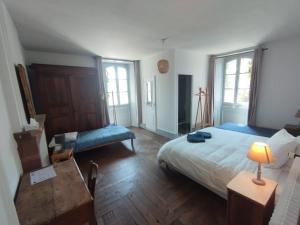 a bedroom with a bed and a table with a lamp at Chambres d'hôtes l'arche d'Yvann in Campuac
