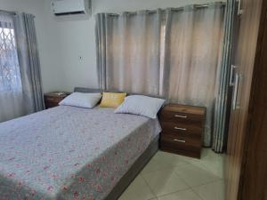 a bedroom with a bed with two pillows and curtains at D11 New Oak in Accra
