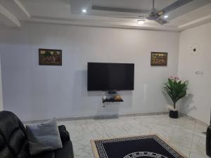 a living room with a flat screen tv on a white wall at D11 New Oak in Accra