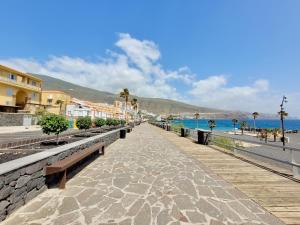 a walkway next to a beach with buildings and the ocean at Vivienda Carolina in Santa Cruz de Tenerife +32 photos