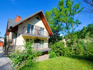 a house with a balcony on the side of it at Apartamenty nad potokiem in Krościenko +32 photos