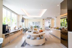 a large kitchen with a table in the middle at Phavina Hotel Rayong SHA Extra Plus in Rayong