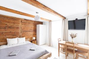 a bedroom with a wooden accent wall and a bed and a desk at WILLOW in Pāvilosta